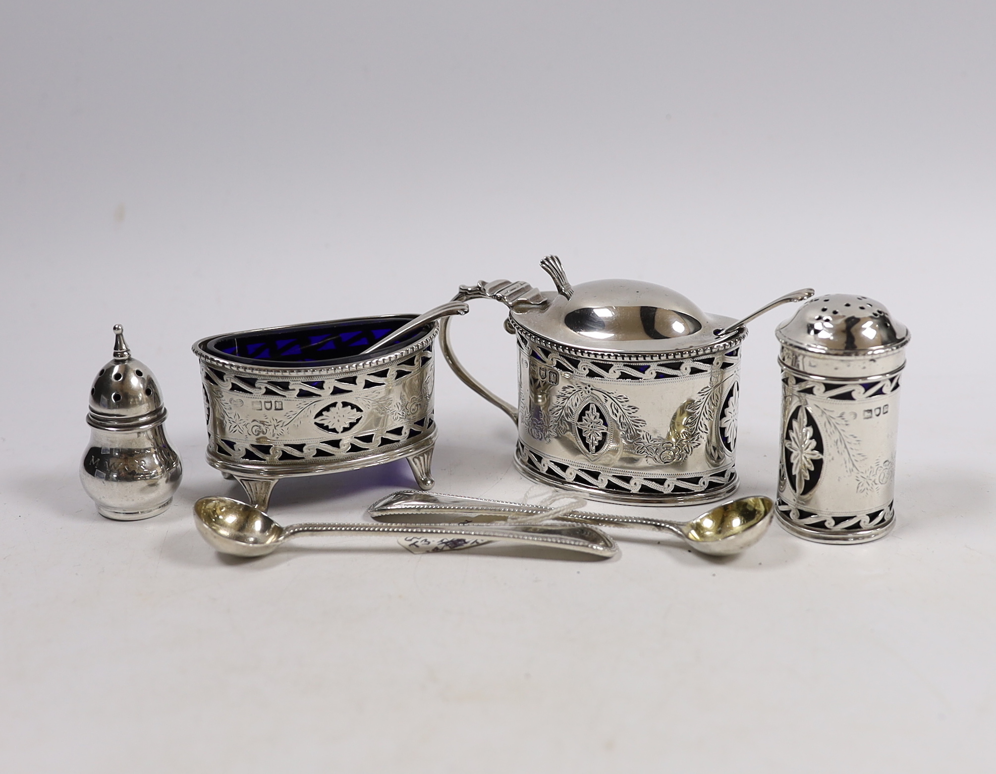 A George V pierced silver oval three piece cruet set and one spoon, Goldsmiths & Silversmiths Co Ltd, London, 1912, two Victorian silver condiment spoons and a sterling pepperette.